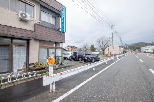 an empty street with cars parked next to a building at 恐竜博物館まで車で5分 自然体験 古来農業体験ができる一棟貸し宿Dinosaur Agri in Katsuyama