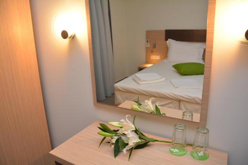 a bedroom with a mirror and a table with flowers at Eco Paralia in Paralia Katerinis