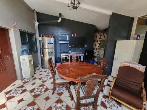 uma cozinha com uma mesa de madeira redonda e cadeiras em Hostal el porrón em Suchitoto