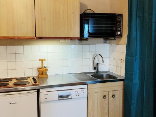 a kitchen with a sink and a microwave at Appartement Les Adrets-Prapoutel, 2 pièces, 5 personnes - FR-1-771-32 in Les Adrets