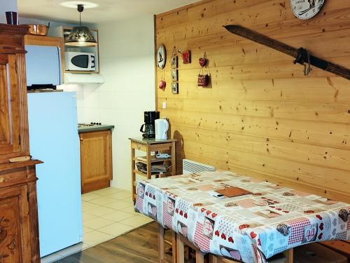 une cuisine avec une table et un réfrigérateur dans l'établissement Appartement familial proche pistes et école de ski - FR-1-771-35, à Les Adrets