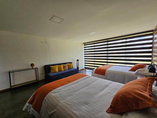a bedroom with two beds and a blue couch at El Chasqui Guest House in Chasqui