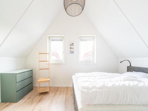 ScherpenisseにあるZeeland Getaway Near Beachのベッドと机のある白い寝室