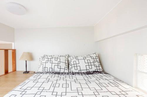 um quarto branco com uma cama e um candeeiro em Lovely Loft Apartment in Kalibo, Aklan em Kalibo