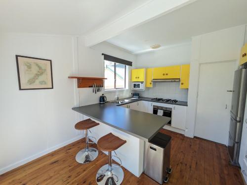a kitchen with yellow cabinets and a black counter top at Sanctuary Retreat in North Avoca