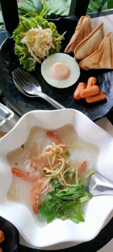 a plate of food with a bowl of soup and vegetables at บีฮายฮิลล์ รีสอร์ต in Ban Khlong Kua