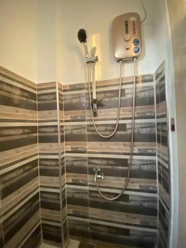 a shower in a bathroom with a glass door at Althea Apartelle in Moalboal
