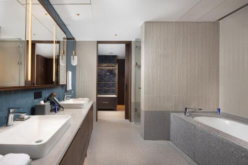 a bathroom with two sinks and a tub and two sinks at New World Guangzhou Hotel in Guangzhou