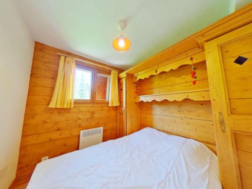 um quarto com uma cama num quarto de madeira em Appartement Les Saisies, 2 pièces, 4 personnes - FR-1-594-320 em Hauteluce