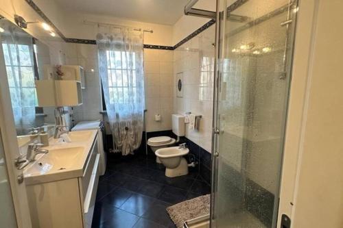 ein Bad mit einem WC und einer Glasdusche in der Unterkunft Cozy apartment with mountain view in Piossasco