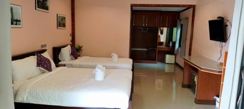 a hotel room with two beds and a television at บีฮายฮิลล์ รีสอร์ต in Ban Khlong Kua