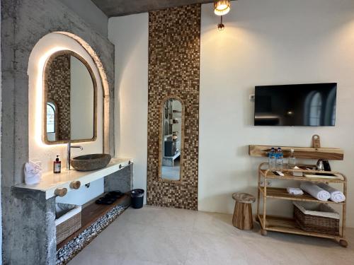 a bathroom with a sink and a mirror at El Tropico Boutique Hotel in Kuta Lombok