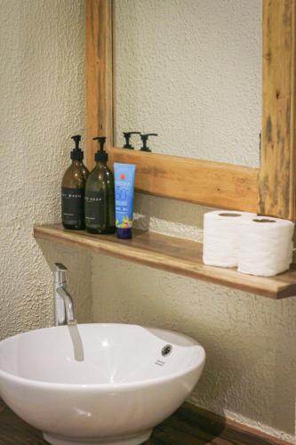 a bathroom with a white sink and a mirror at Happiness Hostel Siargao in General Luna