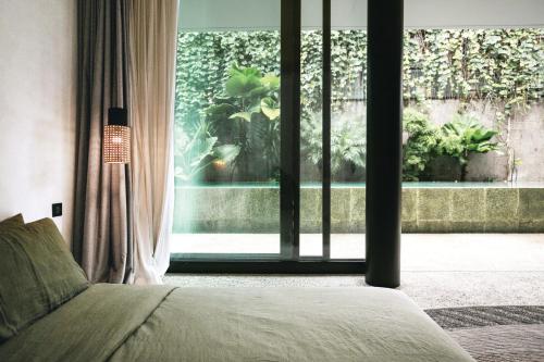 een slaapkamer met een bed en een groot raam bij Sandhouse Berawa in Canggu