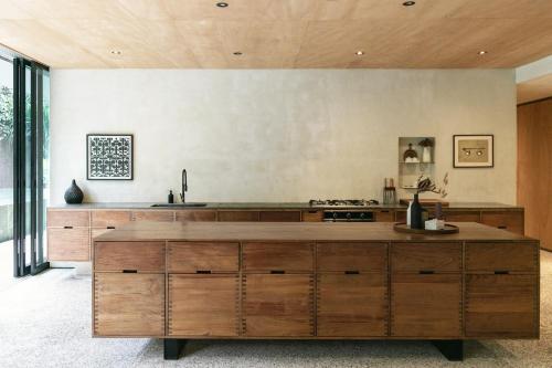 een keuken met een groot houten eiland in een kamer bij Sandhouse Berawa in Canggu