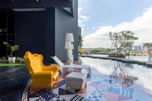 a patio with yellow chairs and a swimming pool at Arte Cheras at Kuala Lumpur in Kuala Lumpur