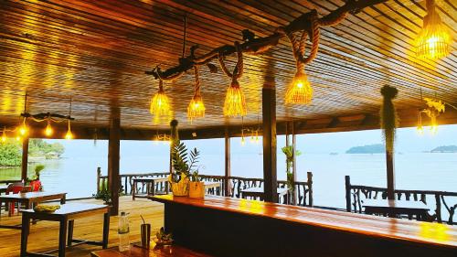a bar in a restaurant with a view of the water at Koh Rong 71 Guesthouse in Koh Rong Island