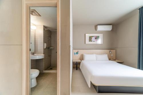 a bedroom with a white bed and a bathroom at Maixinge Hotel - shuttle bus to Shanghai Pudong International Airport in Shanghai