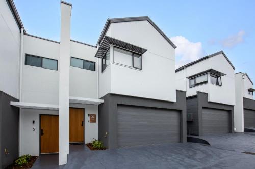 a white house with two garage doors at East Side Sands - Pet Friendly - 5 Mins Walk to Beach in Culburra Beach