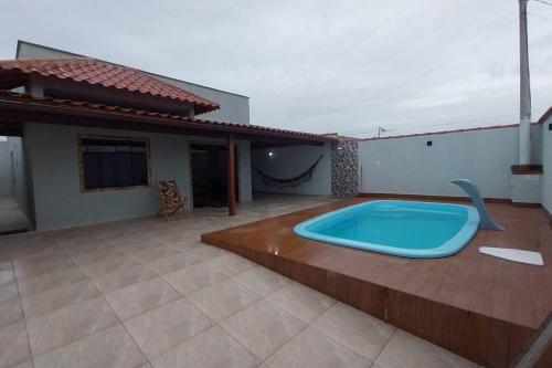 uma grande banheira de hidromassagem sentada num deque ao lado de uma casa em Casa de Temporada no Paraíso de Arraial do Cabo em Arraial do Cabo