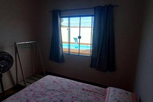 a bedroom with a window with a view of a pool at Casa de Temporada no Paraíso de Arraial do Cabo in Arraial do Cabo