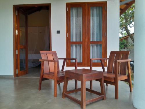 un paio di sedie e un tavolo su un portico di Bokka Almeida a Hikkaduwa