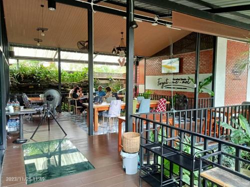 a restaurant with tables and people sitting at tables at บีฮายฮิลล์ รีสอร์ต in Ban Khlong Kua