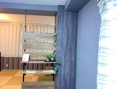 a room with a table and a wooden wall at Yiyihouse shinsaibashi in Osaka