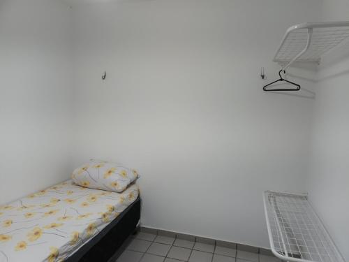 a bed in a room with a white wall at Apartamento no terreo in Natal