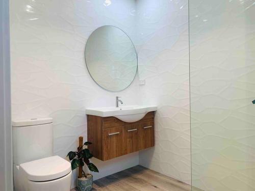 ein Badezimmer mit einem WC, einem Waschbecken und einem Spiegel in der Unterkunft Kangarloo Retreat 