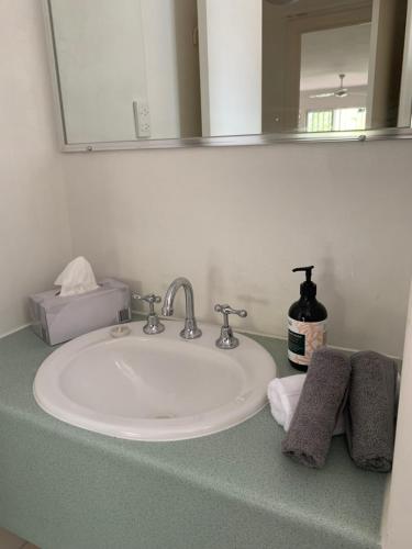 a bathroom counter with a sink and a mirror at Beachfront at Silver Sands Hervey Bay in Hervey Bay