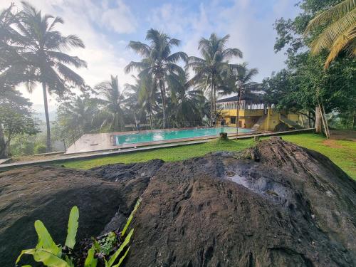 una gran roca frente a una casa con palmeras en The Nature's Resort, Hanwella, 