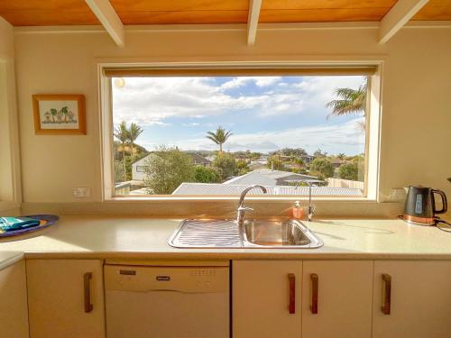 a kitchen with a sink and a window at Princes Retreat in Ngunguru