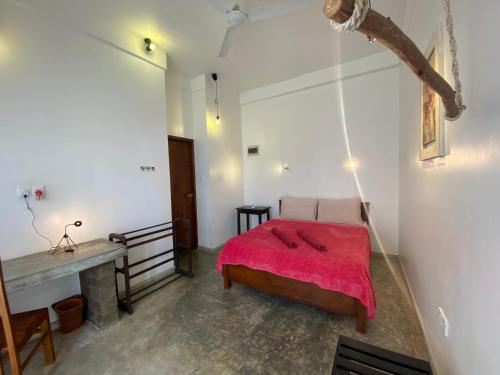 a bedroom with a bed with a red blanket at Mirage Beach House at Morava Court in Hikkaduwa