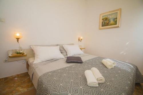 1 dormitorio con 1 cama con 2 toallas en Apartments Arc - 5 M From Beach, en Poljica