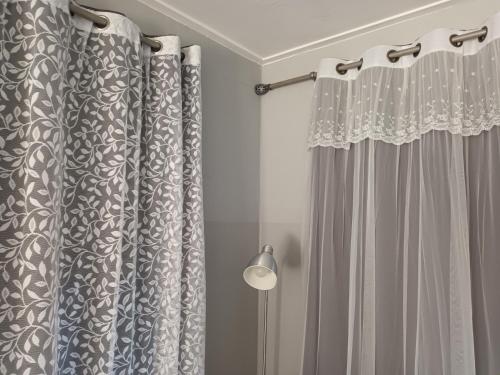 a bathroom with curtains and a lamp in a room at Honey Bear Pension in Pyeongchang