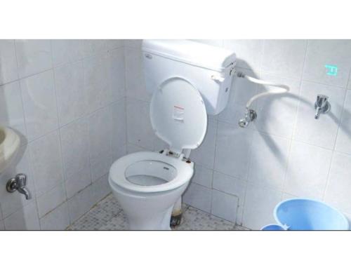 a bathroom with a toilet with the lid up at Snow Peak Guest House, Pahalgam in Pahalgām
