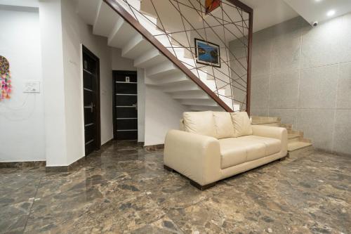 a white couch sitting in a room with stairs at The Golden Sunrise Hotel in Nainital