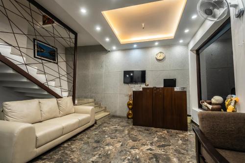 a living room with a couch and a tv at The Golden Sunrise Hotel in Nainital