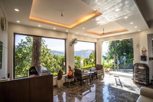 a large living room with large windows and a view at The Golden Sunrise Hotel in Nainital