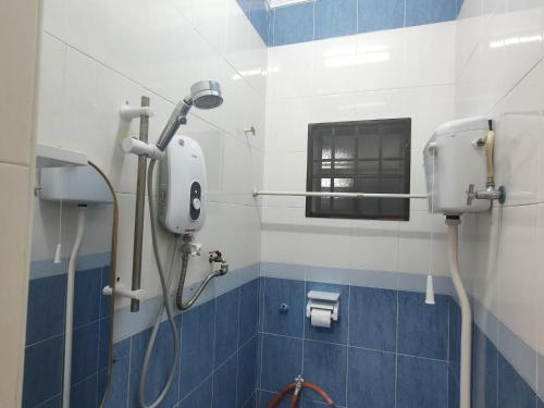 uma casa de banho com um chuveiro com azulejos azuis e brancos em Kapar Nala 34A /3 Rooms/4-8 pax em Kapar