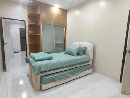 ein Zimmer mit einem Bett mit grünen Kissen darauf in der Unterkunft Kapar Nala 34A /3 Rooms/4-8 pax in Kapar