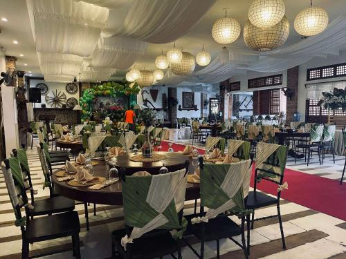 une salle à manger avec des tables, des chaises et des lustres dans l'établissement Casa Lorenzo powered by Cocotel, à Locsin