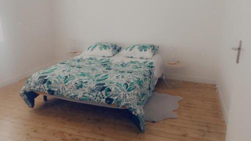 - une chambre dotée d'un lit avec une couverture verte et blanche dans l'établissement Maison centre historique, à Laval