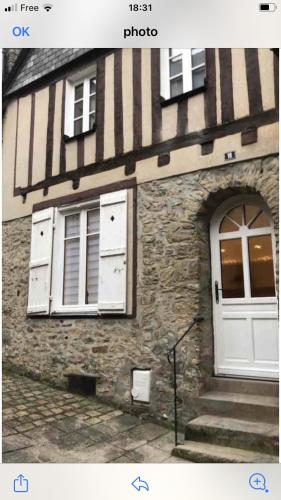 um edifício com uma porta branca, janelas e escadas em Maison centre historique em Laval