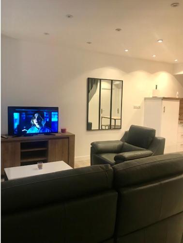 ein Wohnzimmer mit einem Sofa und einem Flachbild-TV in der Unterkunft Maison centre historique in Laval