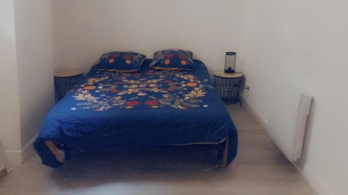 ein Schlafzimmer mit einem Bett mit einer blauen Bettdecke und Kissen in der Unterkunft Maison centre historique in Laval