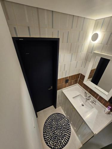 a bathroom with a black door and a sink at Miracle Suite house 201 pool villa in Incheon