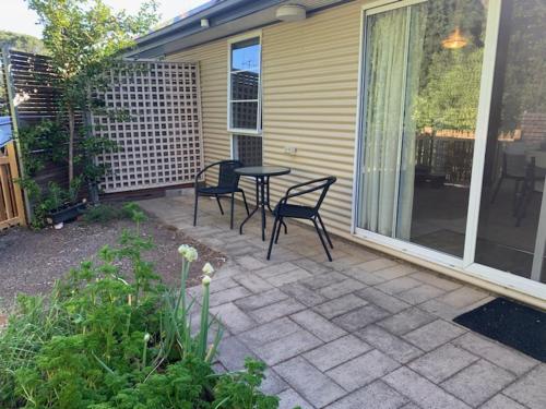 a patio with two chairs and a table on a house at Very Comfortable Granny Flat in Yass