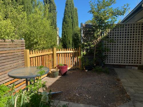 a garden with a wooden fence and a table at Very Comfortable Granny Flat in Yass